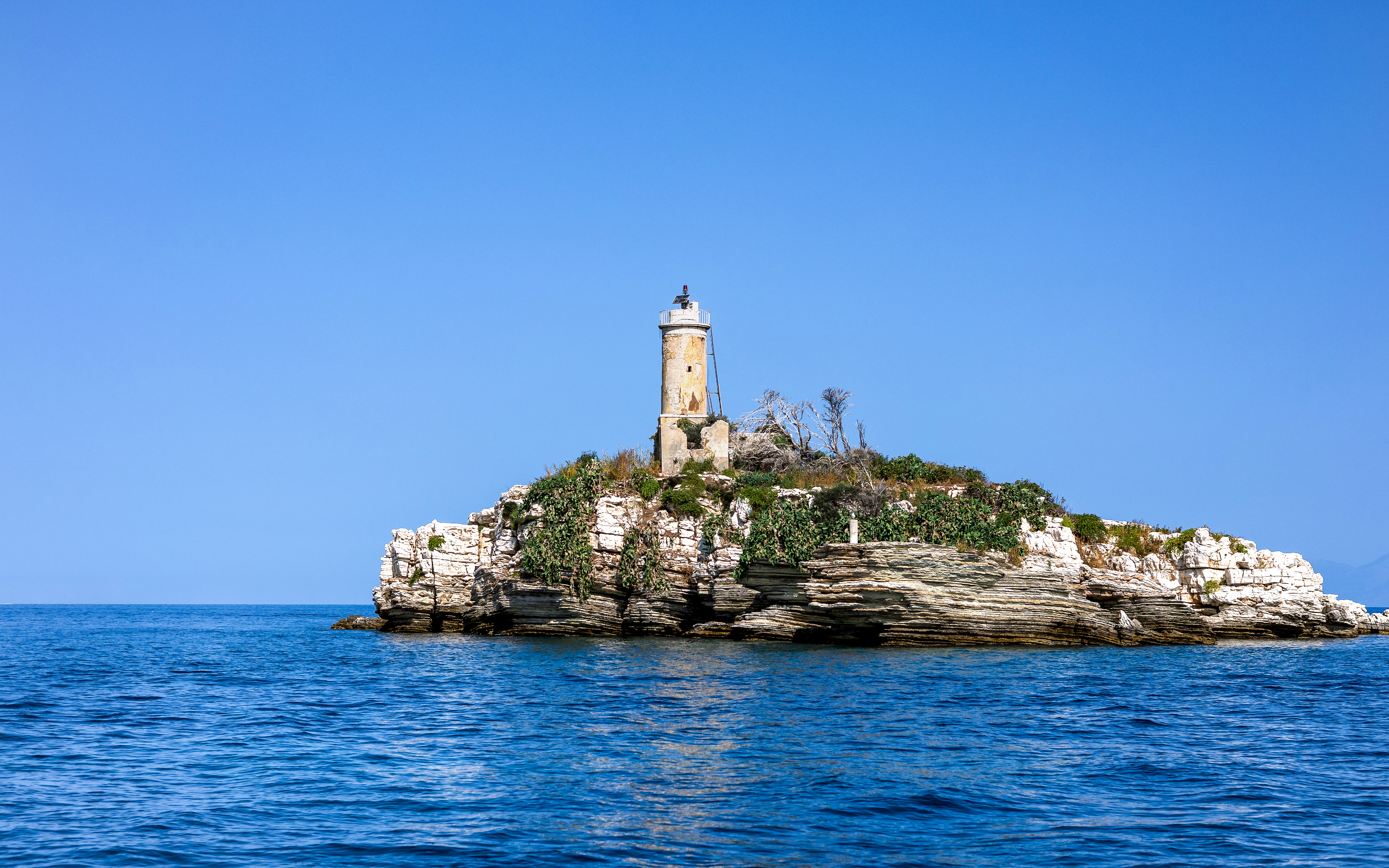 Peristeres Lighthouse on Kaparelli rock surrounded by sea, Corfu, Greece.