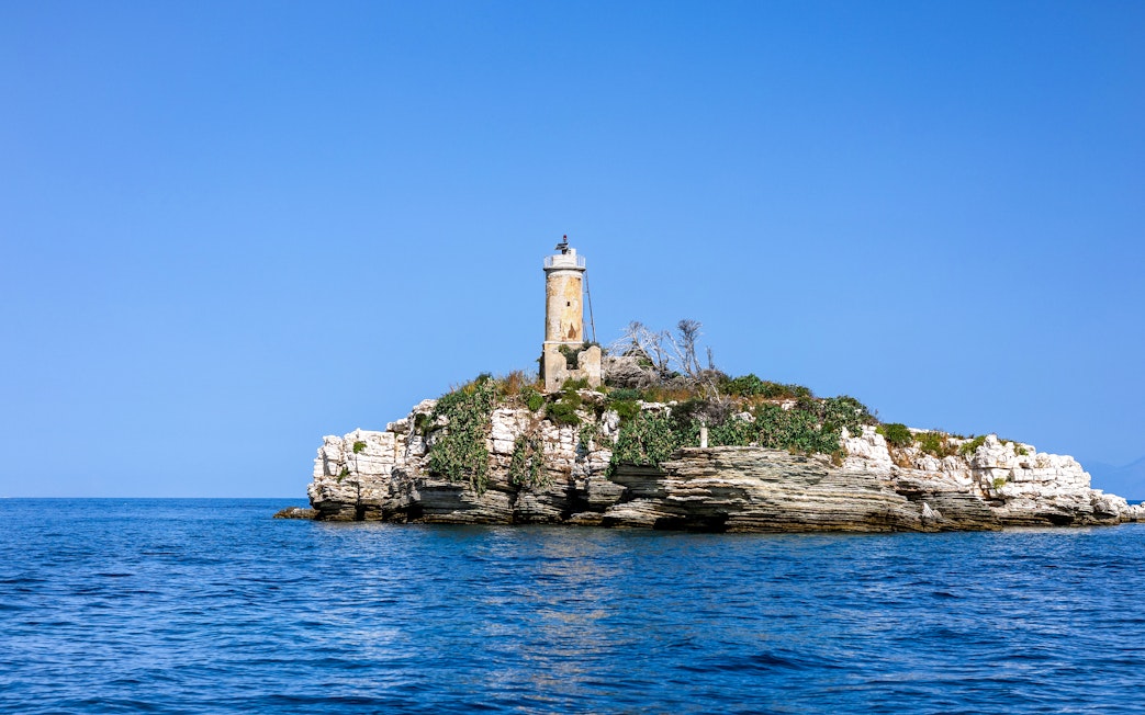 Peristeres Lighthouse on Kaparelli rock surrounded by sea, Corfu, Greece.