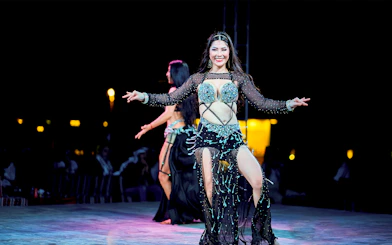 Woman dancing at Dubai desert safari experience.