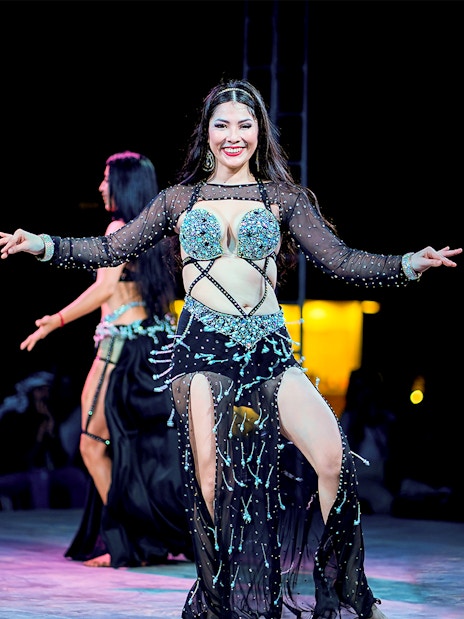 Woman dancing at Dubai desert safari experience.