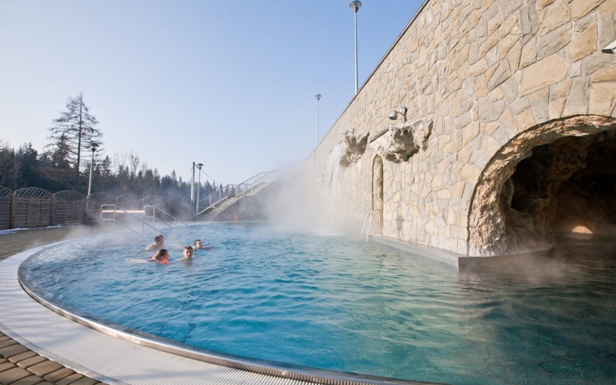 Outdoor hot bath pool with steam rising, part of Zakopane tour experience.