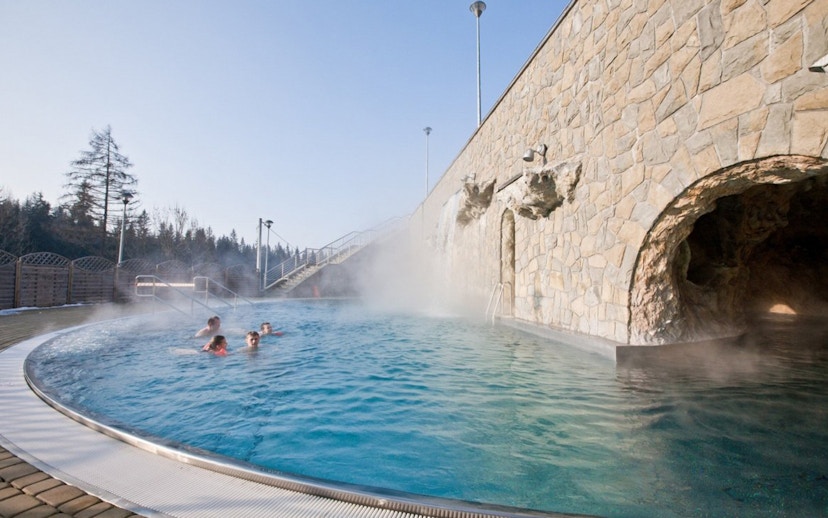 Outdoor hot bath pool with steam rising, part of Zakopane tour experience.