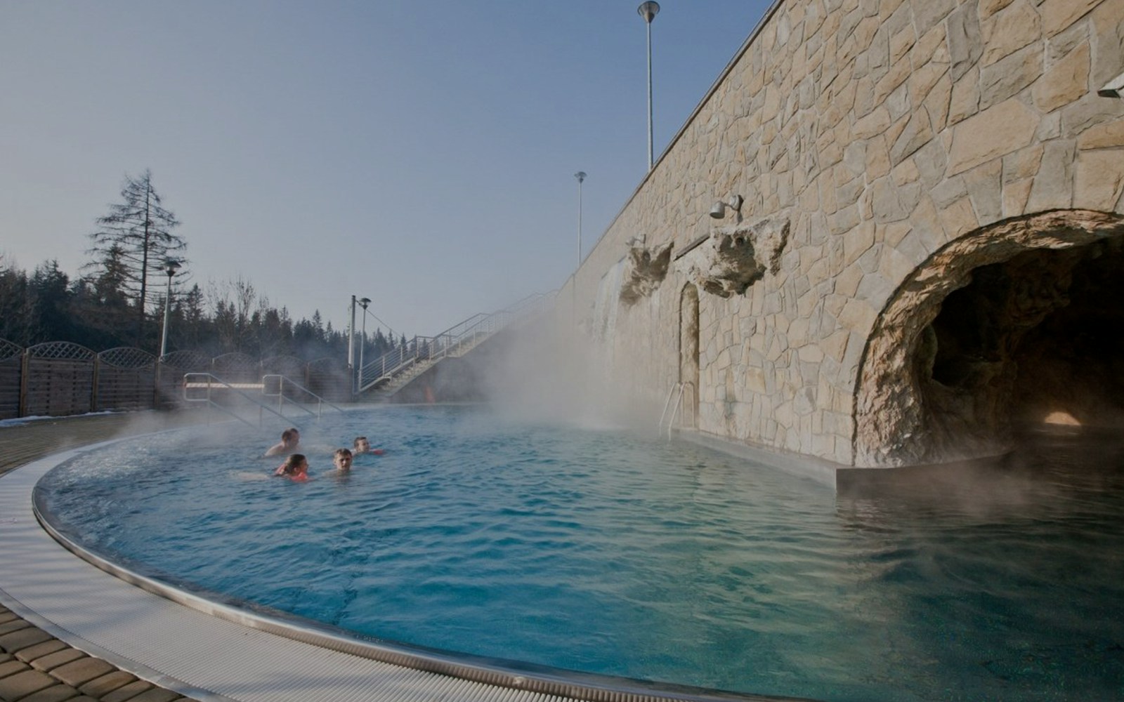 Outdoor hot bath pool with steam rising, part of Zakopane tour experience.