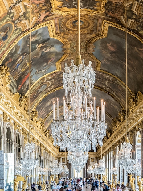Hall of Mirrors, Versailles Palace, ornate chandeliers and ceiling frescoes, France.