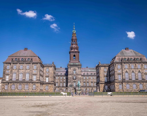 Christiansborg Palace in Copenhagen with tourists exploring the historic architecture.