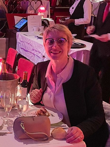 Couple dining at Moulin Rouge with wine and elegant table setting.
