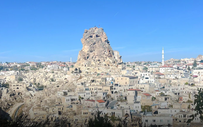 Ortahisar Fortress towering over Cappadocia's unique rock formations and historic townscape, Turkey.