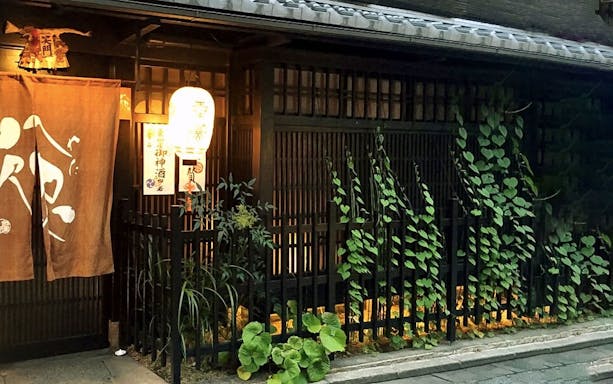 Traditional Gion restaurant entrance with lantern and plants, Kyoto.