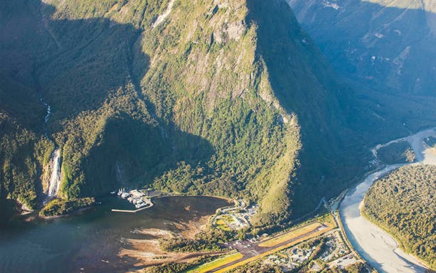 Aerial view of Milford Sound with lush mountains and winding river, Queenstown flyover tour.