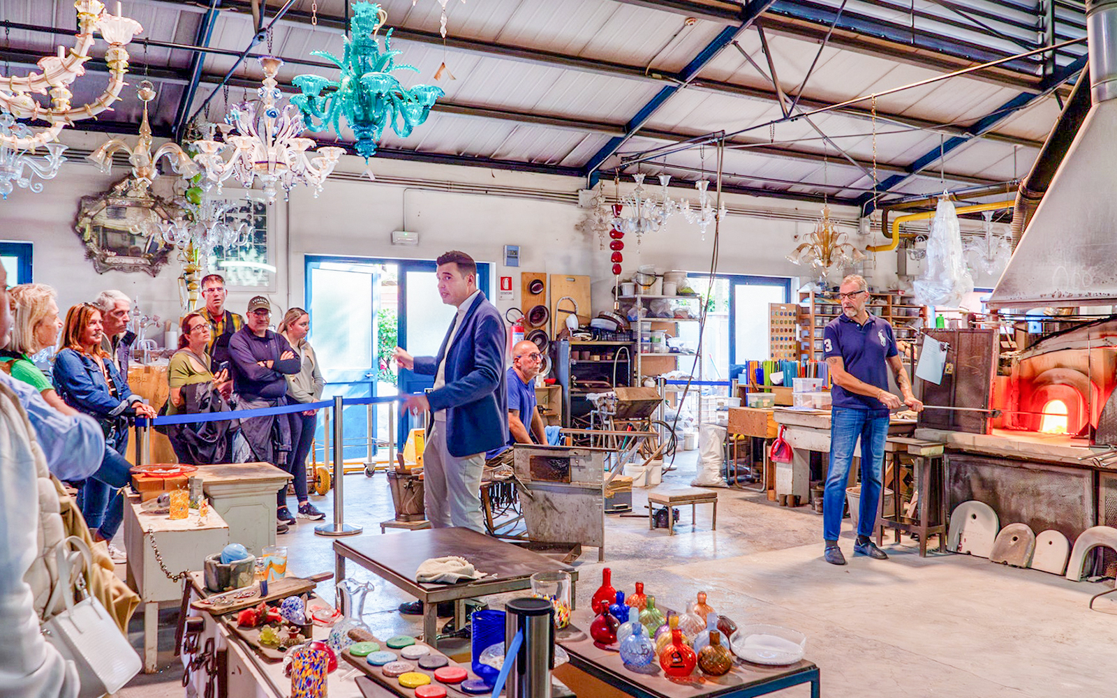 Guests observing glass blowing demonstration at Murano workshop, Venice.
