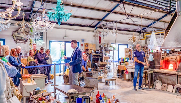 Guests observing glass blowing demonstration at Murano workshop, Venice.