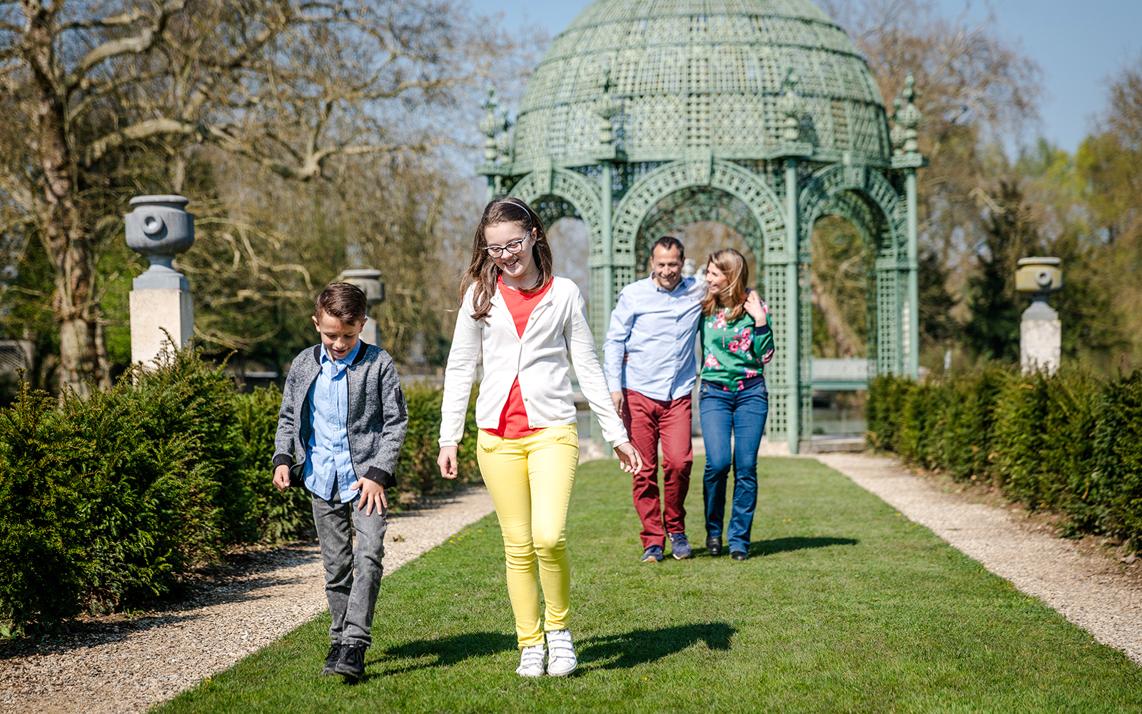 Family walking in the gardens of Chateau of Chantilly, France.