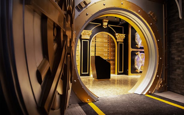 Vault entrance at MONOPOLY DREAMS™️ Hong Kong with gold accents and safe deposit boxes.