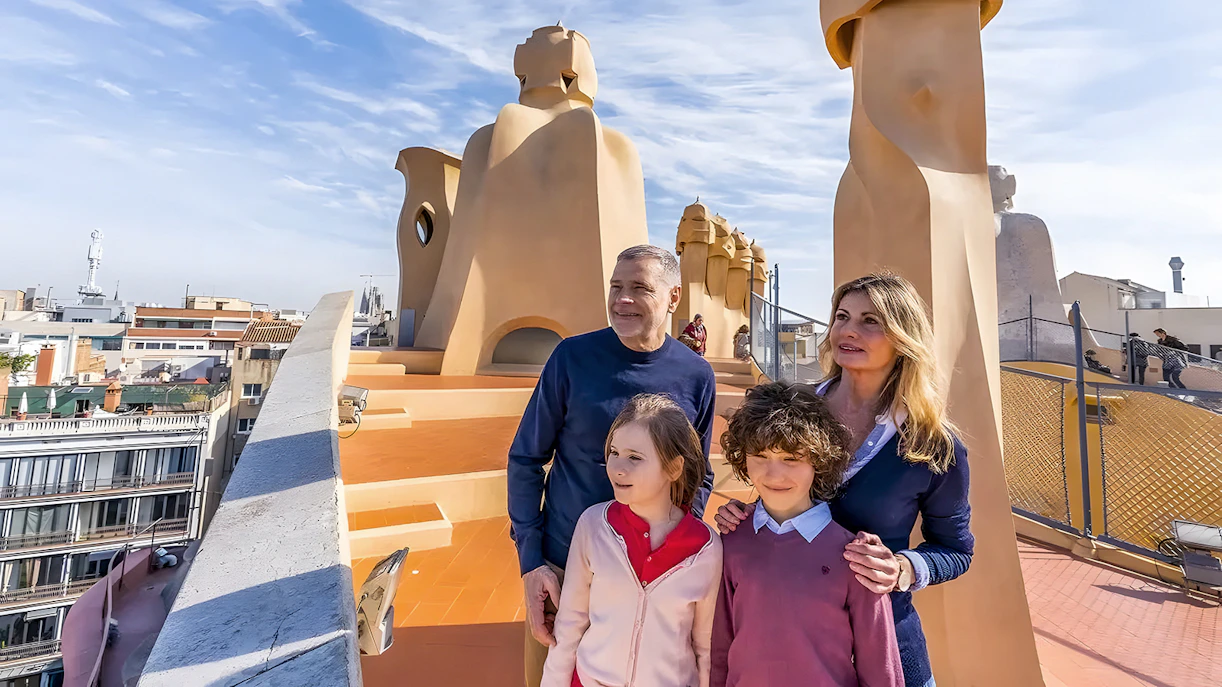 Family exploring rooftop of La Pedrera, Barcelona during guided tour.