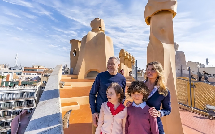 Family exploring rooftop of La Pedrera, Barcelona during guided tour.