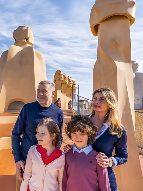 Family exploring rooftop of La Pedrera, Barcelona during guided tour.