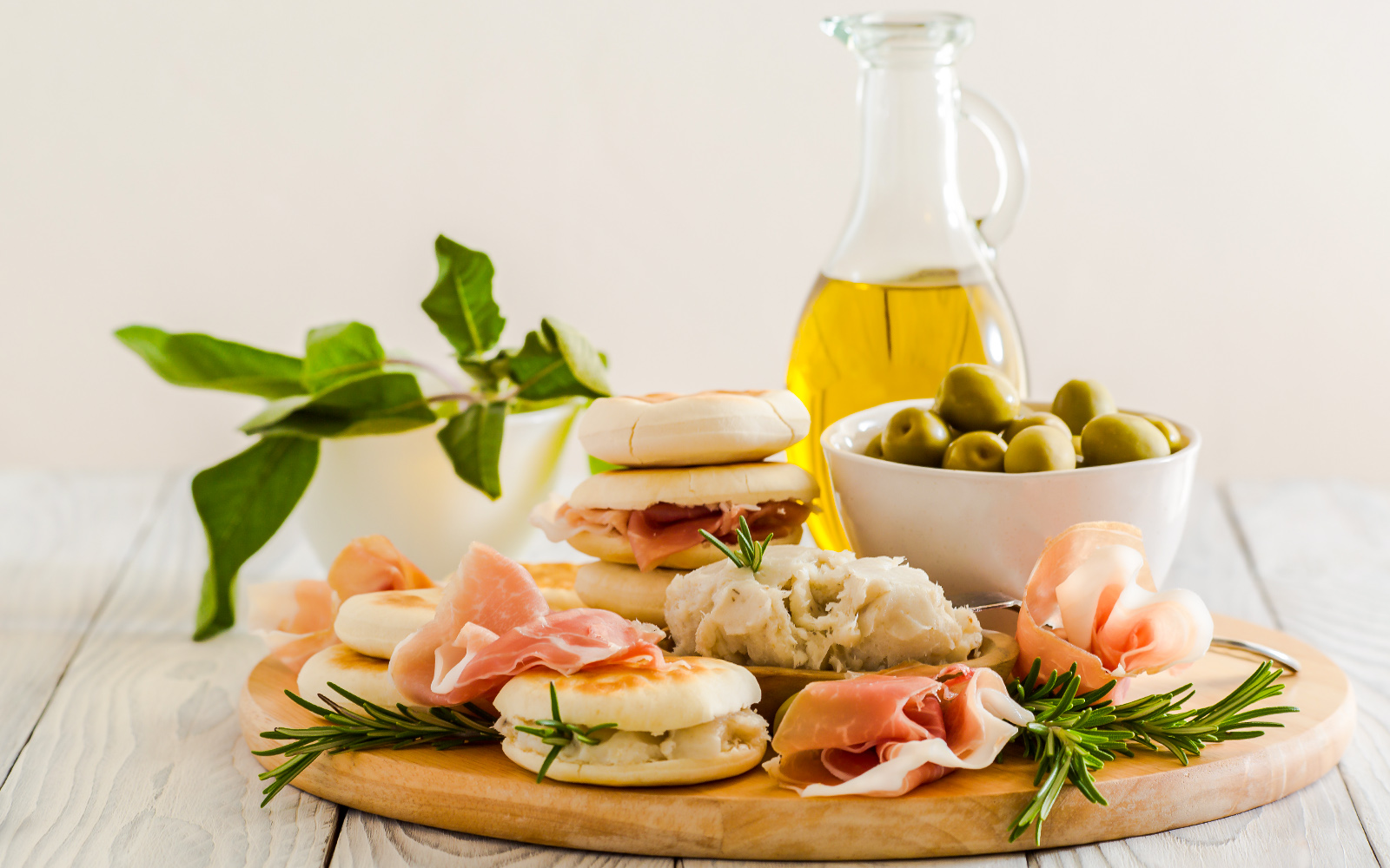Platter with cured meats, bread, olives, and olive oil for vinegar cellar tasting tour.