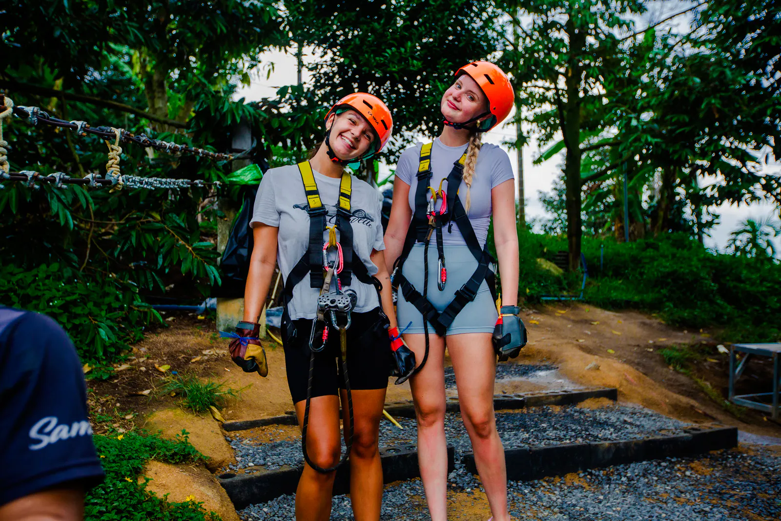 Two people in harnesses ready for ziplining at Tree Bridge Zipline, Koh Samui.