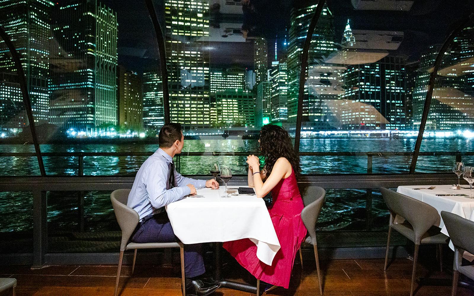 Couple dining on New Jersey Signature Cruise with city skyline view.