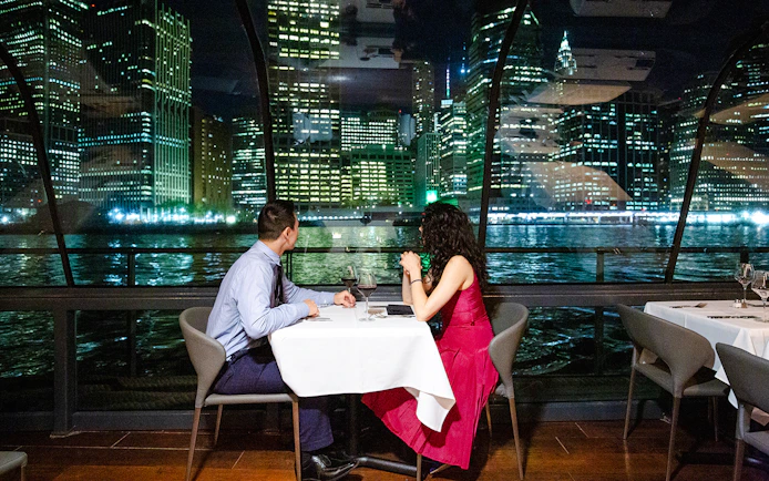Couple dining on New Jersey Signature Cruise with city skyline view.