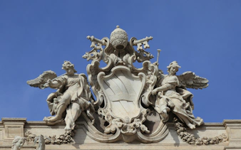Angels and papal symbols atop Trevi Fountain in Rome, Italy.