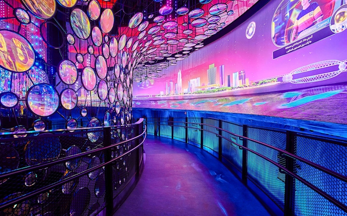 Exhibit with colorful lights and cityscape at Expo City Dubai.