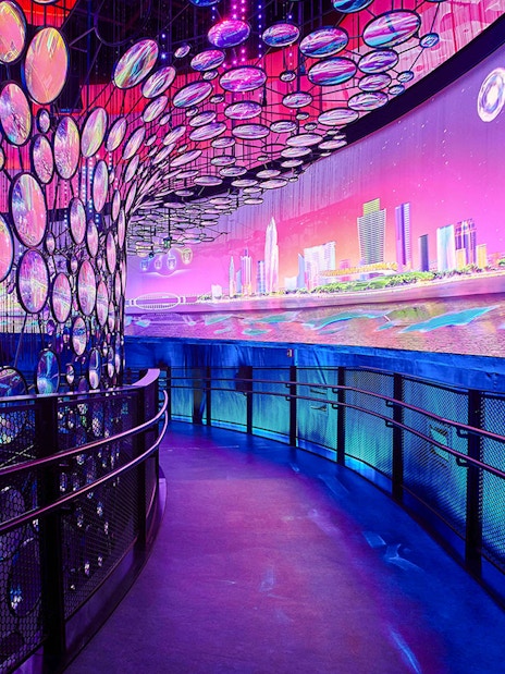 Exhibit with colorful lights and cityscape at Expo City Dubai.