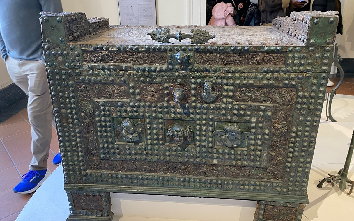 Ancient bronze chest with decorative reliefs at Naples National Archaeological Museum.