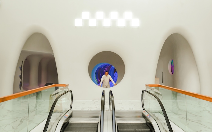 Man standing in a futuristic hallway at AYA Universe, Dubai's WAFI City Mall.