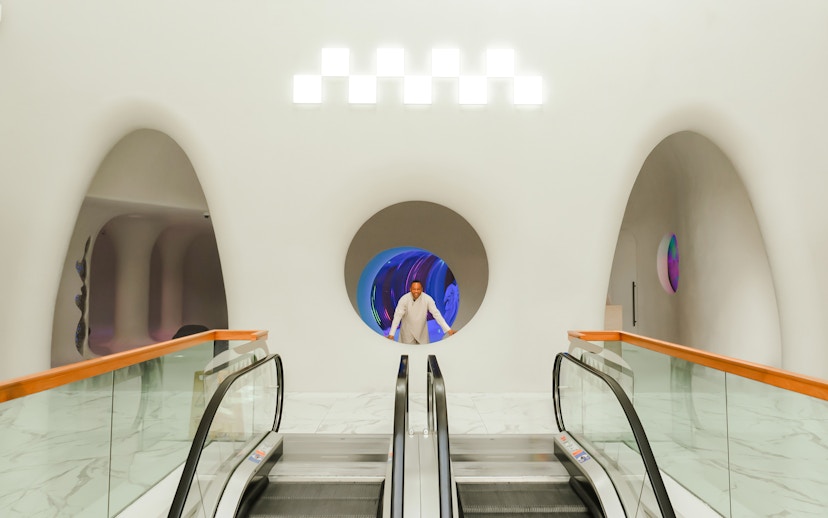 Man standing in a futuristic hallway at AYA Universe, Dubai's WAFI City Mall.