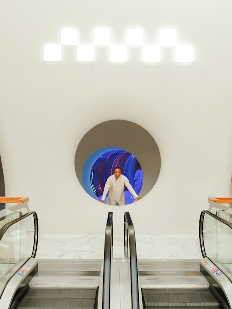 Man standing in a futuristic hallway at AYA Universe, Dubai's WAFI City Mall.