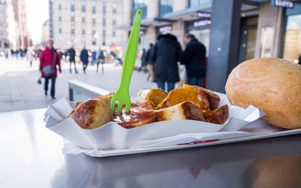 Currywurst and bread roll on a table in HafenCity during a 3-hour guided tour.