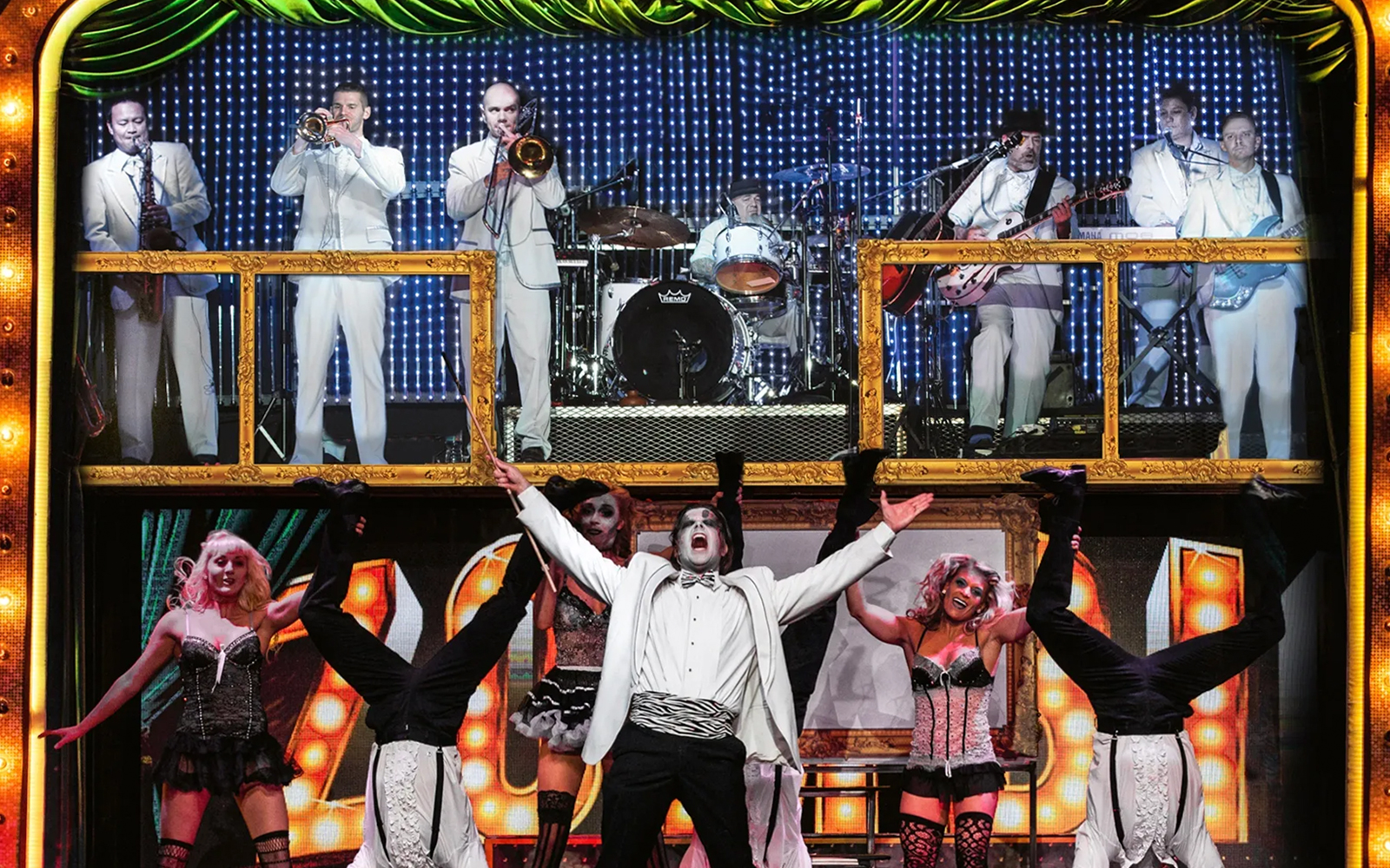 Performers in zombie-themed burlesque show with live band in background.