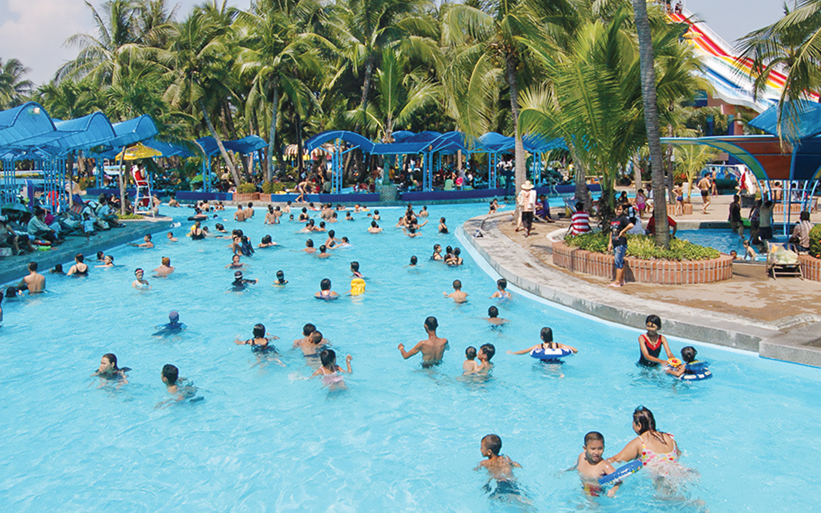 Wave pool at Siam Amazing Park with people enjoying the water and surrounding attractions in Bangkok, Thailand.