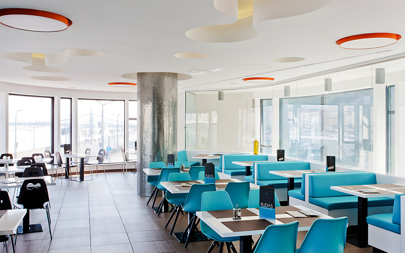 Indoor seating area at a restaurant in Rudas Bath, Budapest, with tables and chairs arranged for dining.