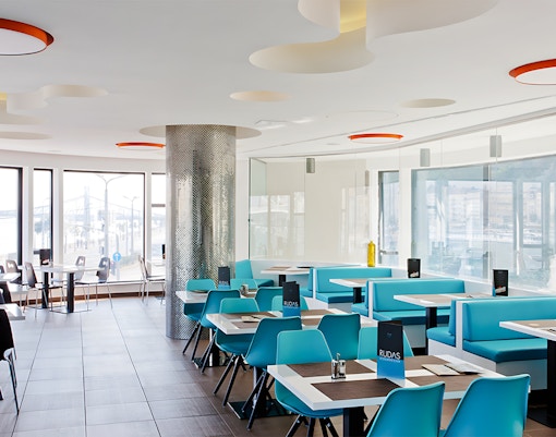Indoor seating area at a restaurant in Rudas Bath, Budapest, with tables and chairs arranged for dining.