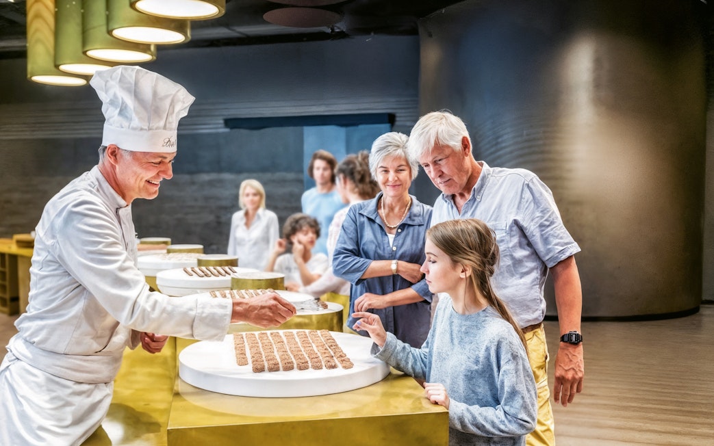 Chocolatier offering samples to visitors at Lindt Home of Chocolate Museum.