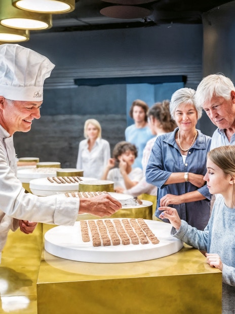 Chocolatier offering samples to visitors at Lindt Home of Chocolate Museum.
