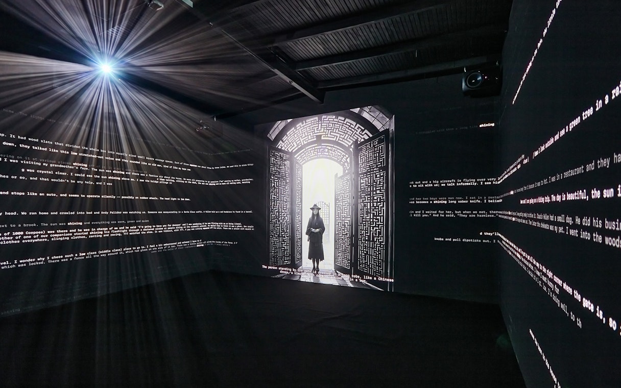Interactive light installation at Light Art Museum with illuminated text and silhouette figure.