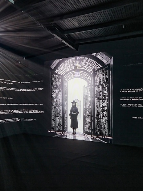 Interactive light installation at Light Art Museum with illuminated text and silhouette figure.