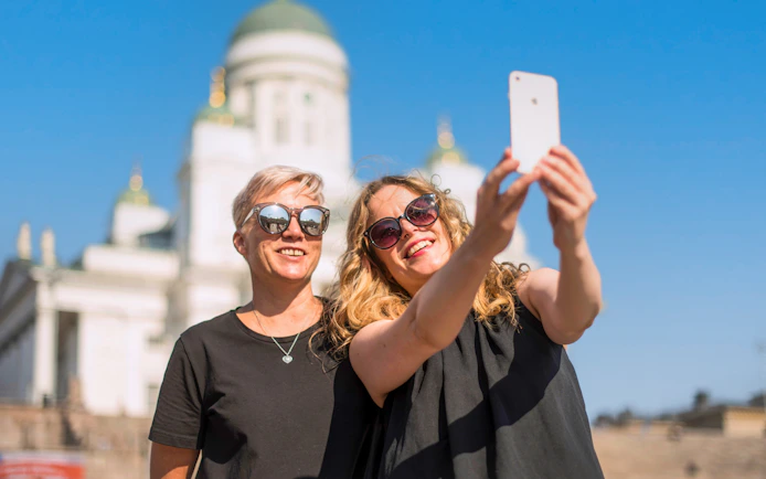 Guests taking a selfie in front of Helsinki Cathedral.