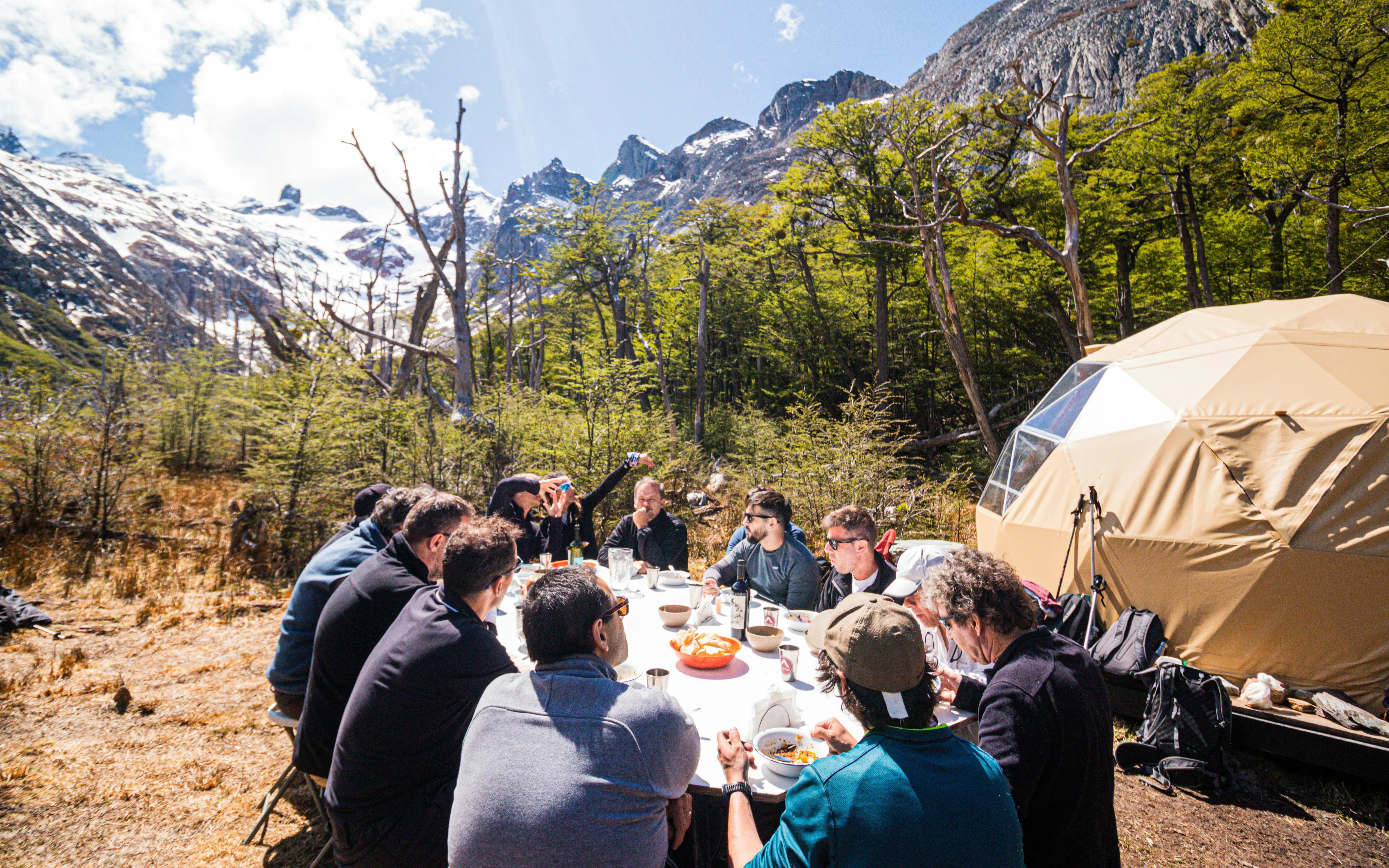 Group enjoying snacks break during Esmeralda Lake Trekking with mountains in the background.