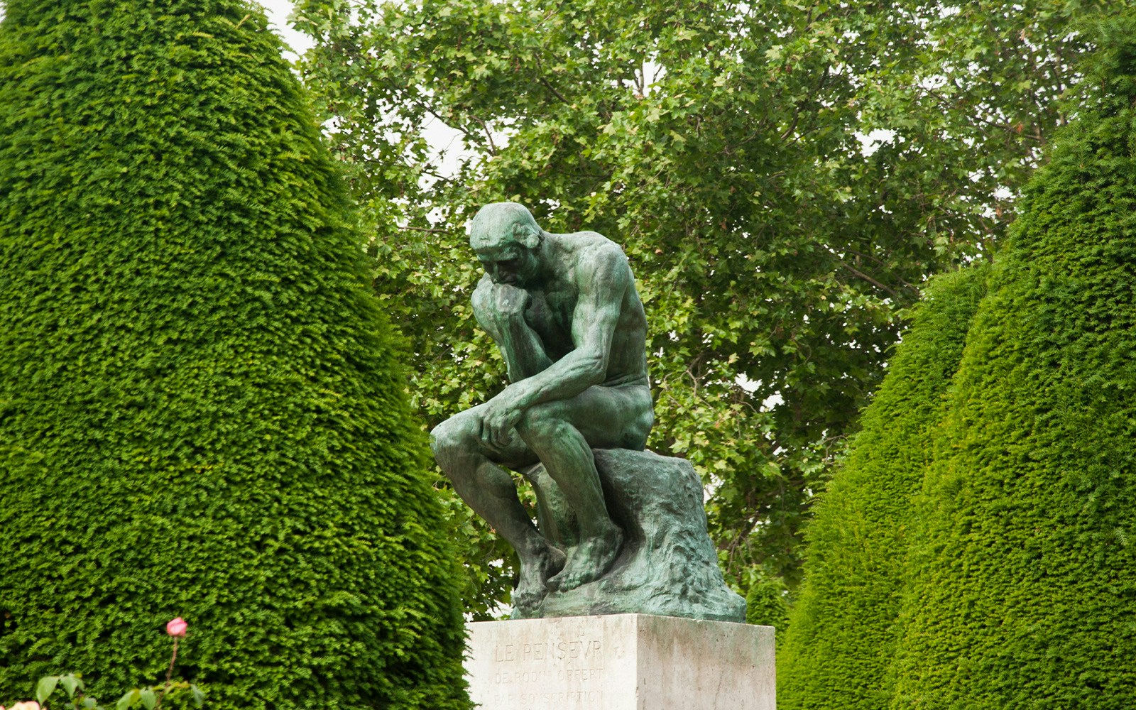Rodin's The Thinker sculpture in a serene garden setting, Paris, France.
