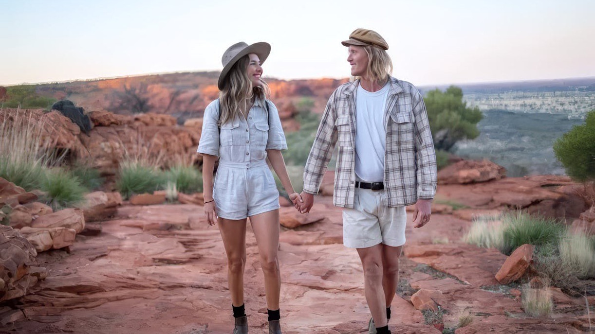 Couple walking on red rock trail in Uluru-Kata Tjuta National Park, Australia.