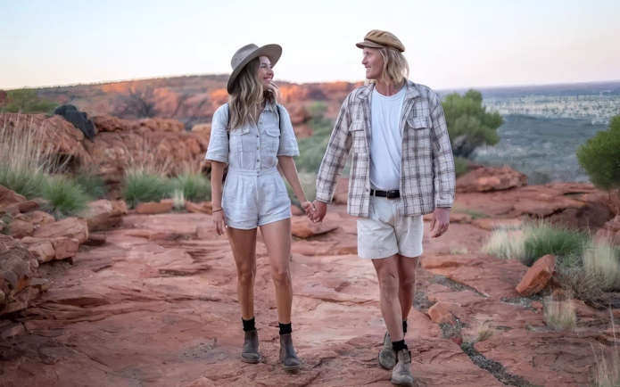 Couple walking on red rock trail in Uluru-Kata Tjuta National Park, Australia.