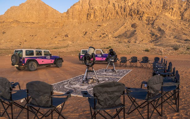 Telescopes and chairs set up for stargazing at Mleiha Space Camp in the desert.