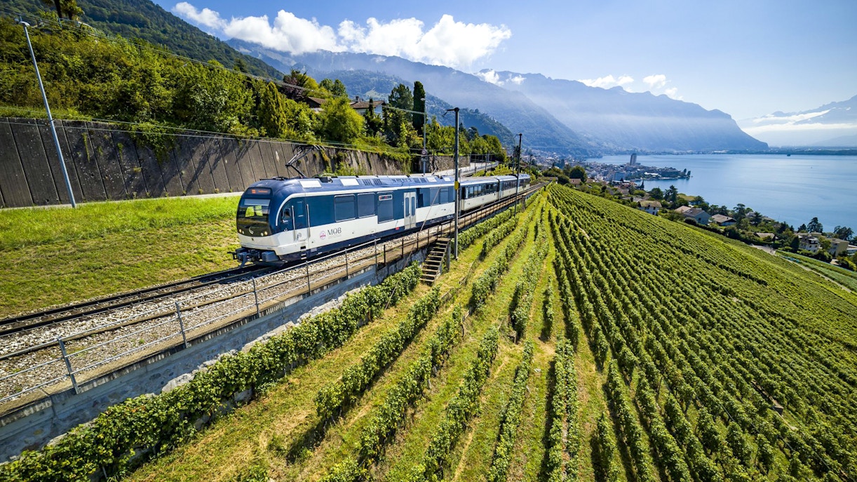 Golden Pass train traveling through Swiss Alps with scenic mountain and lake views.