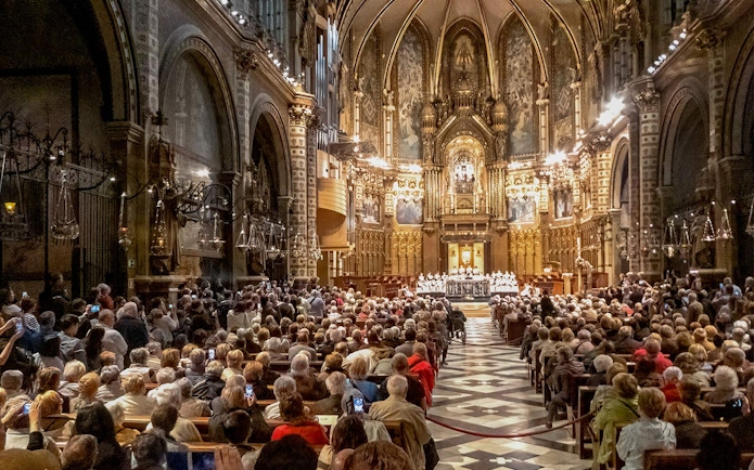 Choir performance at Escolania de Montserrat in a crowded basilica.