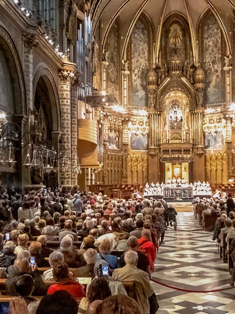 Choir performance at Escolania de Montserrat in a crowded basilica.