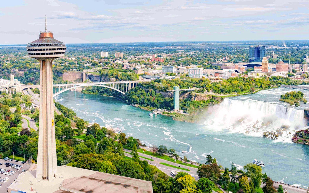 Skylon Tower with view of Niagara Falls and mist rising from the water.